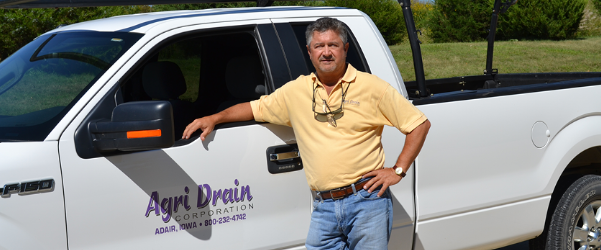 Agri Drain Owner Charlie Schafer Standing in Front of His Work Truck