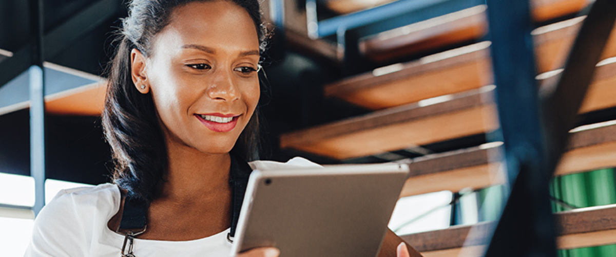 A Woman Holding an iPad, Discovering the Benefits of ACH Payments