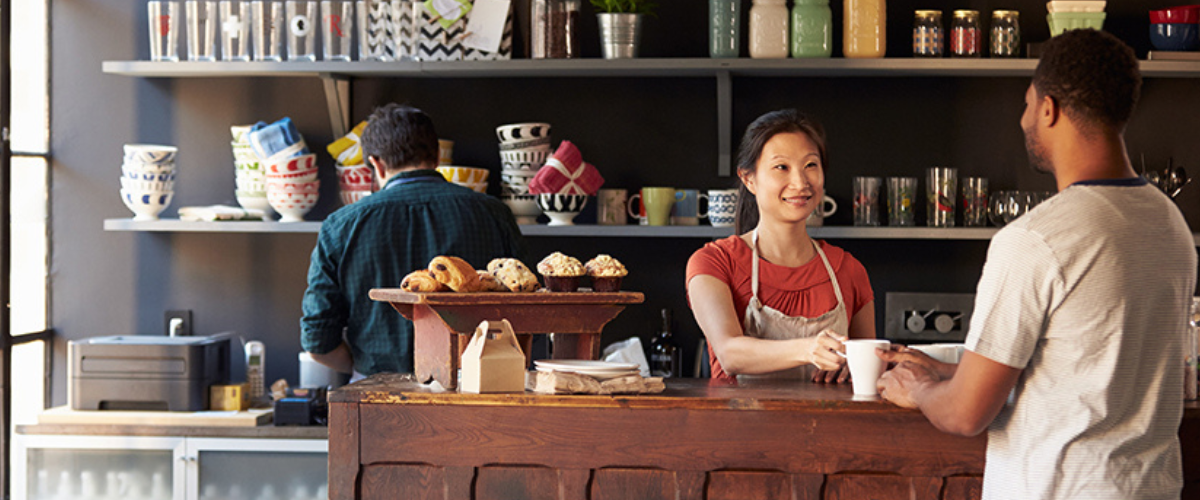 Image of Woman Serving a Man in a Coffee Shop