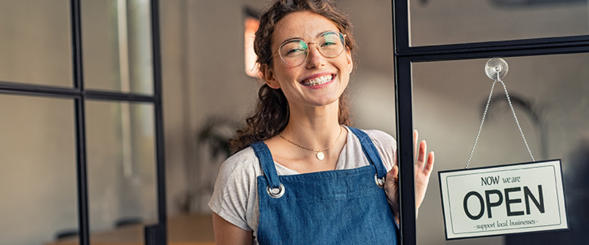 Small business Owner Welcoming Customers with an Open Sign on the Door