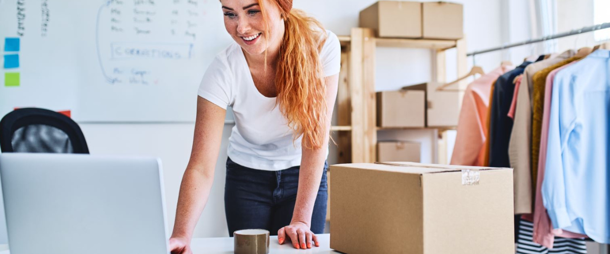 Woman Looking at Computer with Boxes in Background