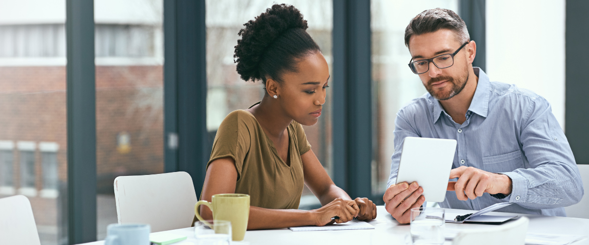 Female and Male Small Business Owners Looking a Tablet That Has a Treasury Management Service for Their Company