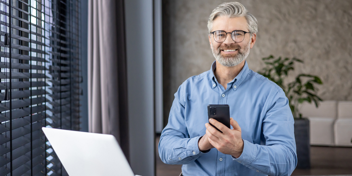 Man smiling and holding cell phone