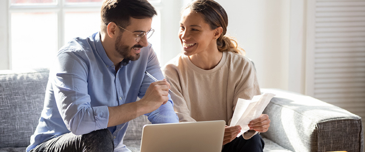 Image of Couple Looking at Laptop and Paperwork