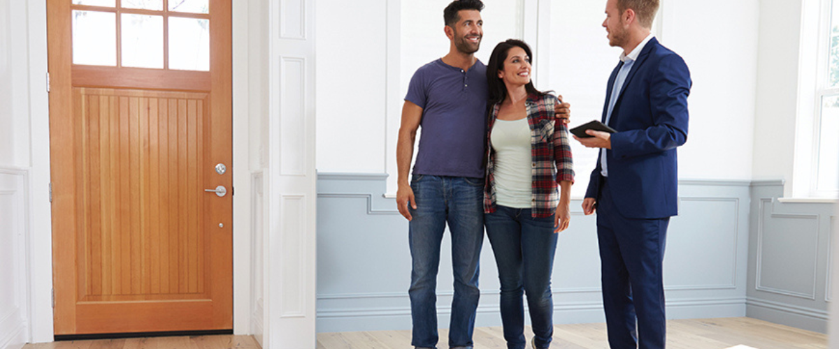 Image of Couple Looking at House with Realtor