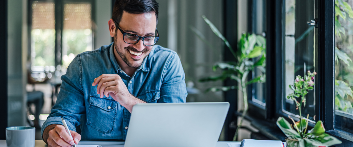 A small business owner looking at his computer using a business mobile banking solution