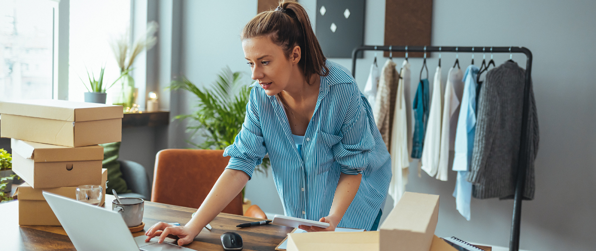 Woman in clothing shop in front of laptop