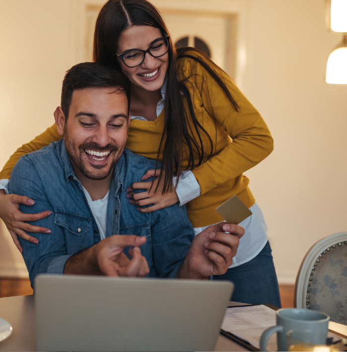 Couple Paying Bills Online Through Their Computer At Home