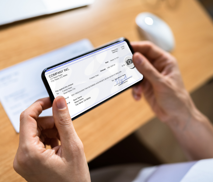 Person Using Their Phone To Mobile Deposit Their Check Into Their Account