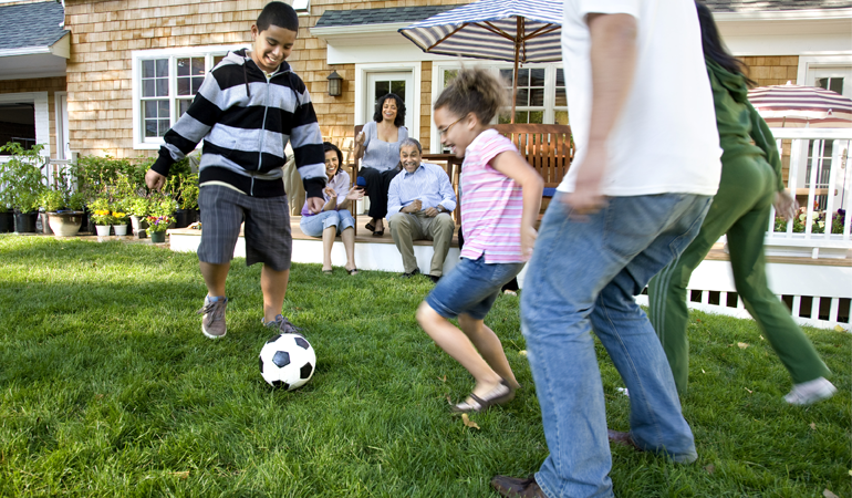 Family Play Soccer Outside Enjoying The Day.