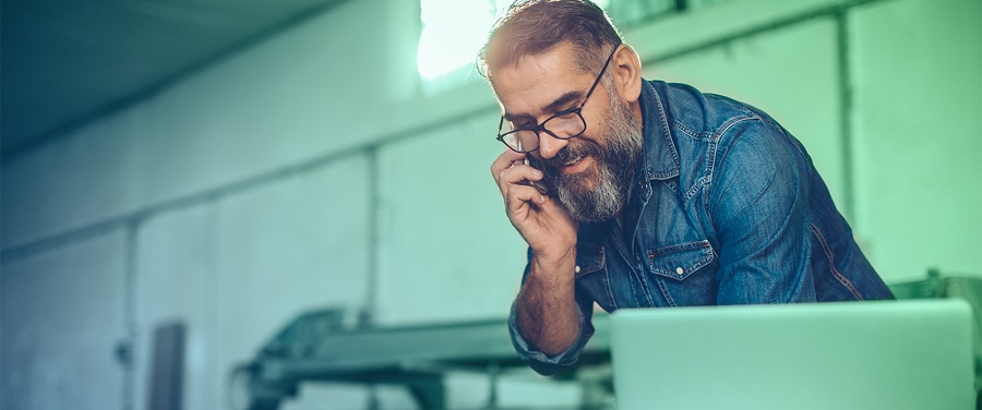 Man on phone in front of computer