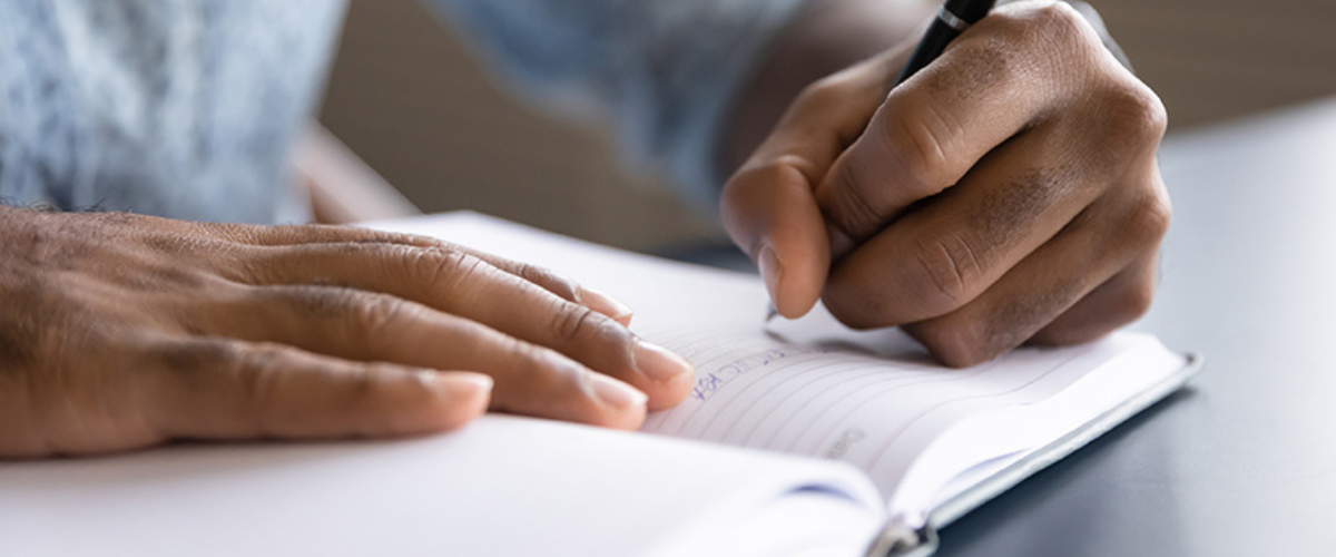 Image of Person Writing in Notebook