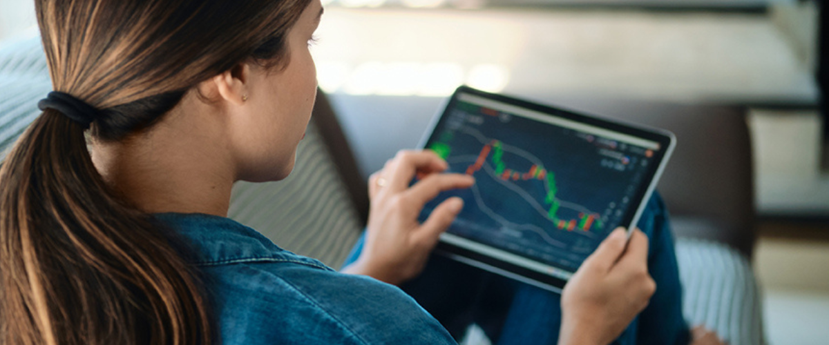 Image of Woman Looking at Stocks on Tablet